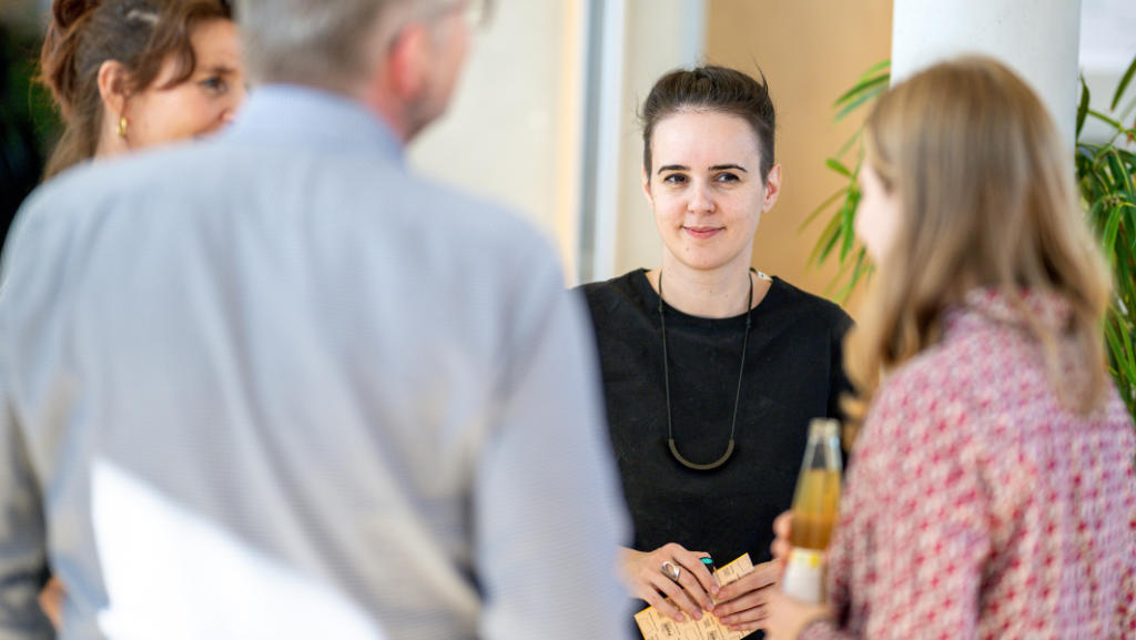 Woman in group standing in circle, paper in hand