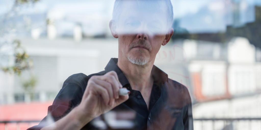 Man writing on window