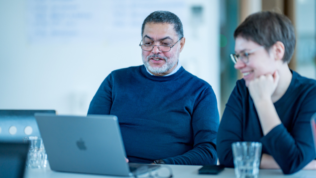 Mann und Frau gemeinsam an einem Tisch vor Laptop