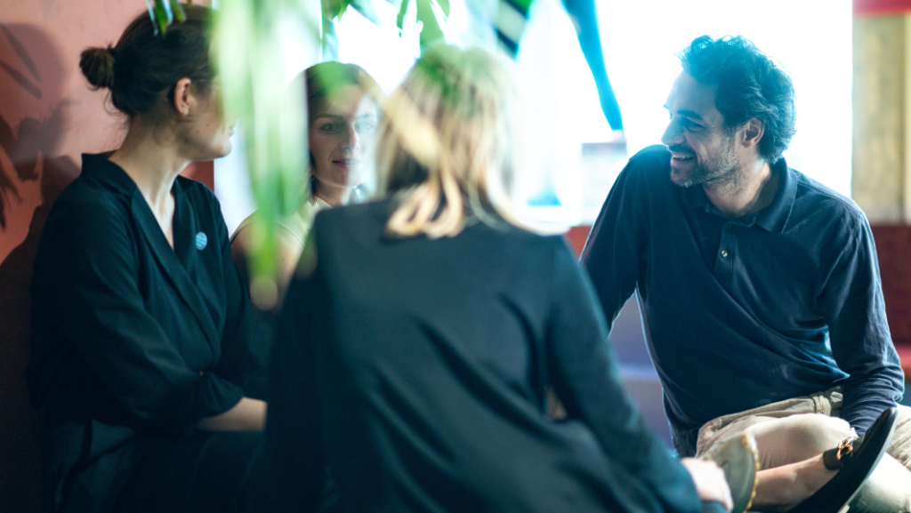 Junge Menschen im Kreis sitzend, im Gespräch, Schriftzug Change That Works Academy