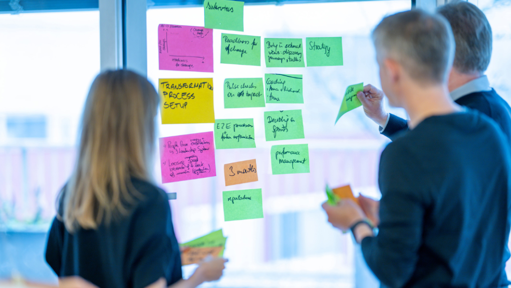 Drei Personen vor Fenster beklebt mit Postits