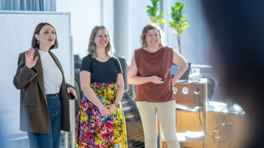 Zwei Frauen, die lachen, eine, die gestikuliert