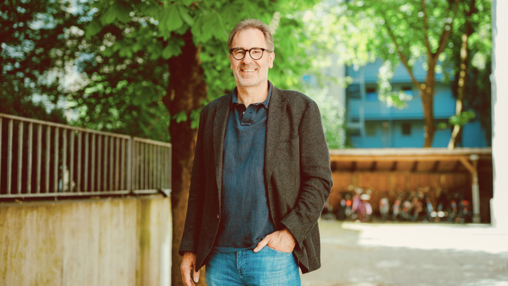 Mann mit Brille und Sakko im Freien