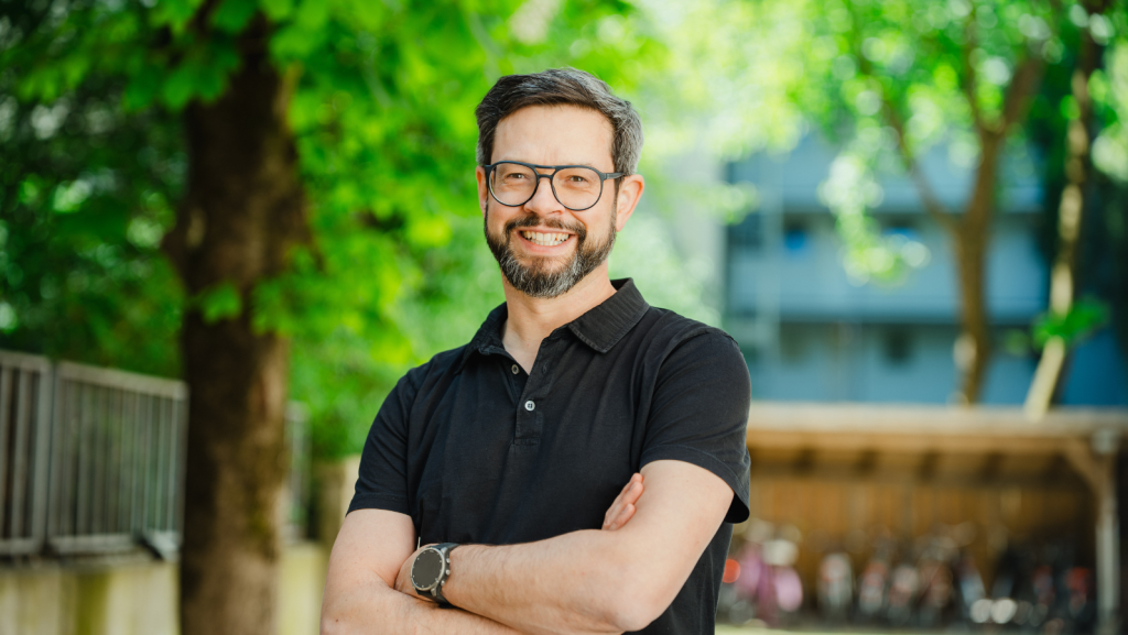 Mann im schwarzem Polo und Brille