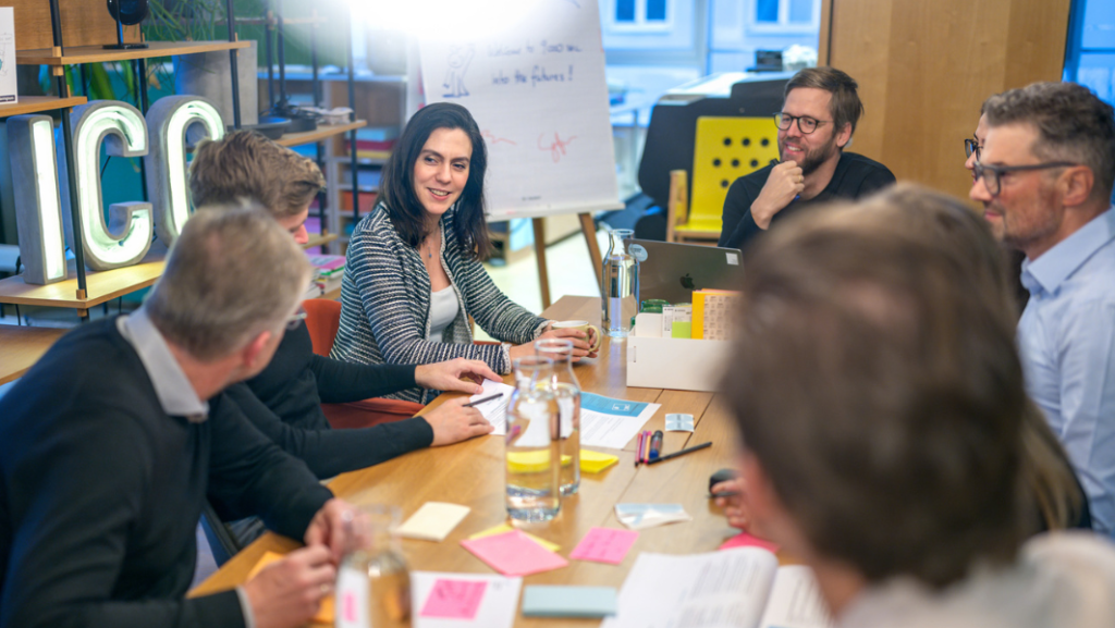 Gruppe von Menschen, die in einer Besprechung an einem Tisch sitzen
