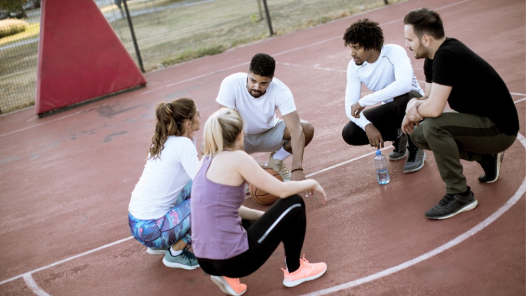 Gruppe von Sportler hockend in Runde in einer Besprechung