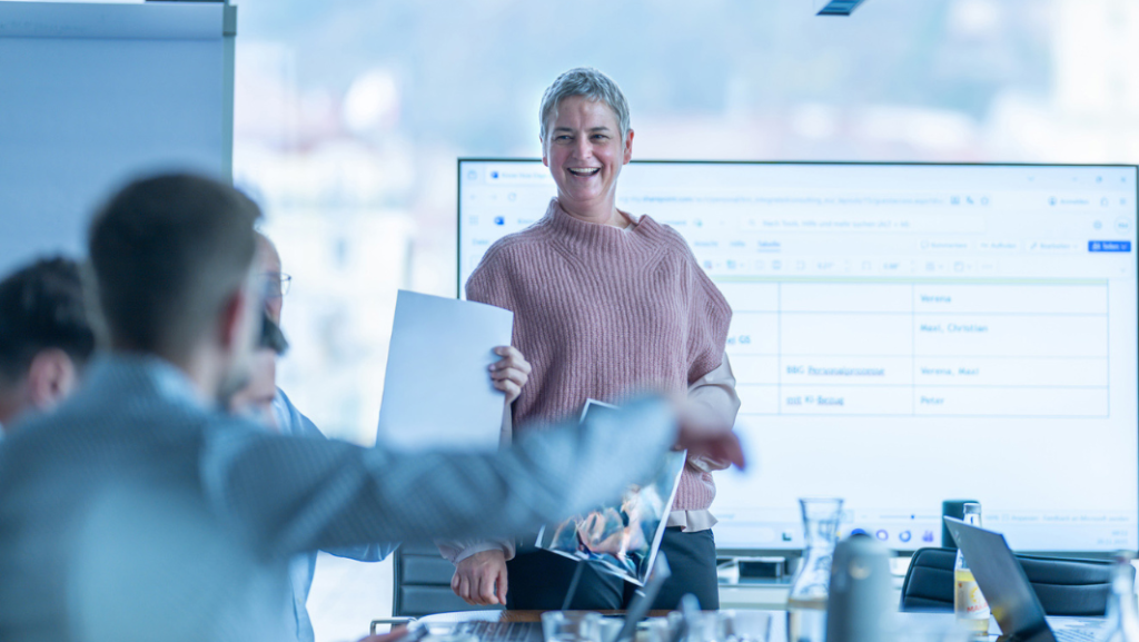 Lachende, stehende Frau in Meeting