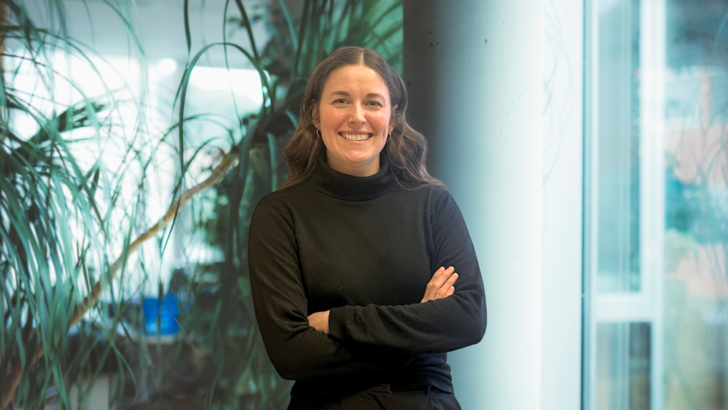 Junge Frau mit langen Haaren in einem Büro vor Pflanzen
