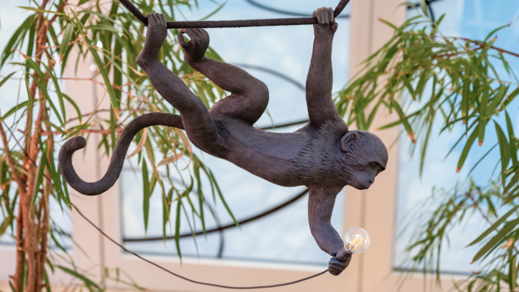 schwingender Affe mit Glühbirne als Lampe