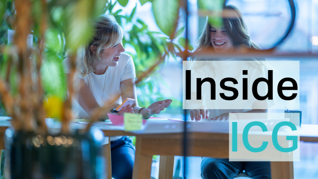 Zwei lachende Frauen arbeitend an einem Hochtisch